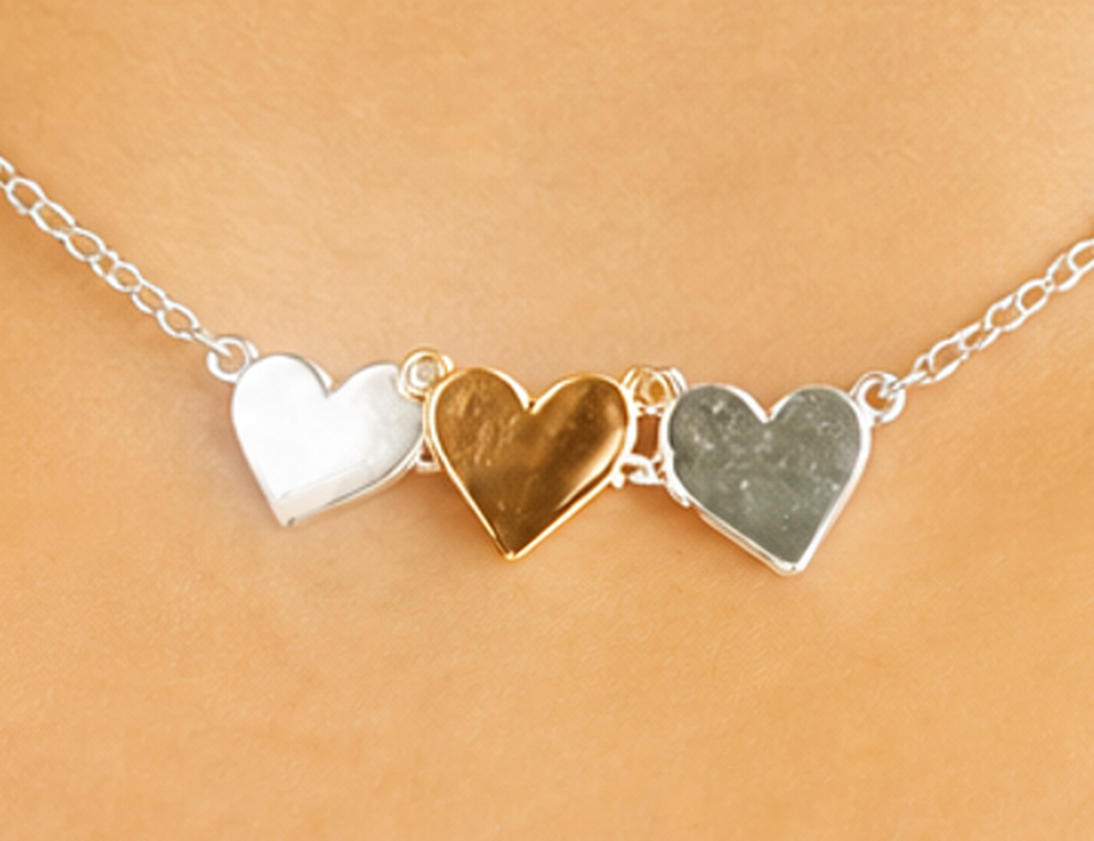 Silver heart charms on a fine chain, worn by Wear Don't Care